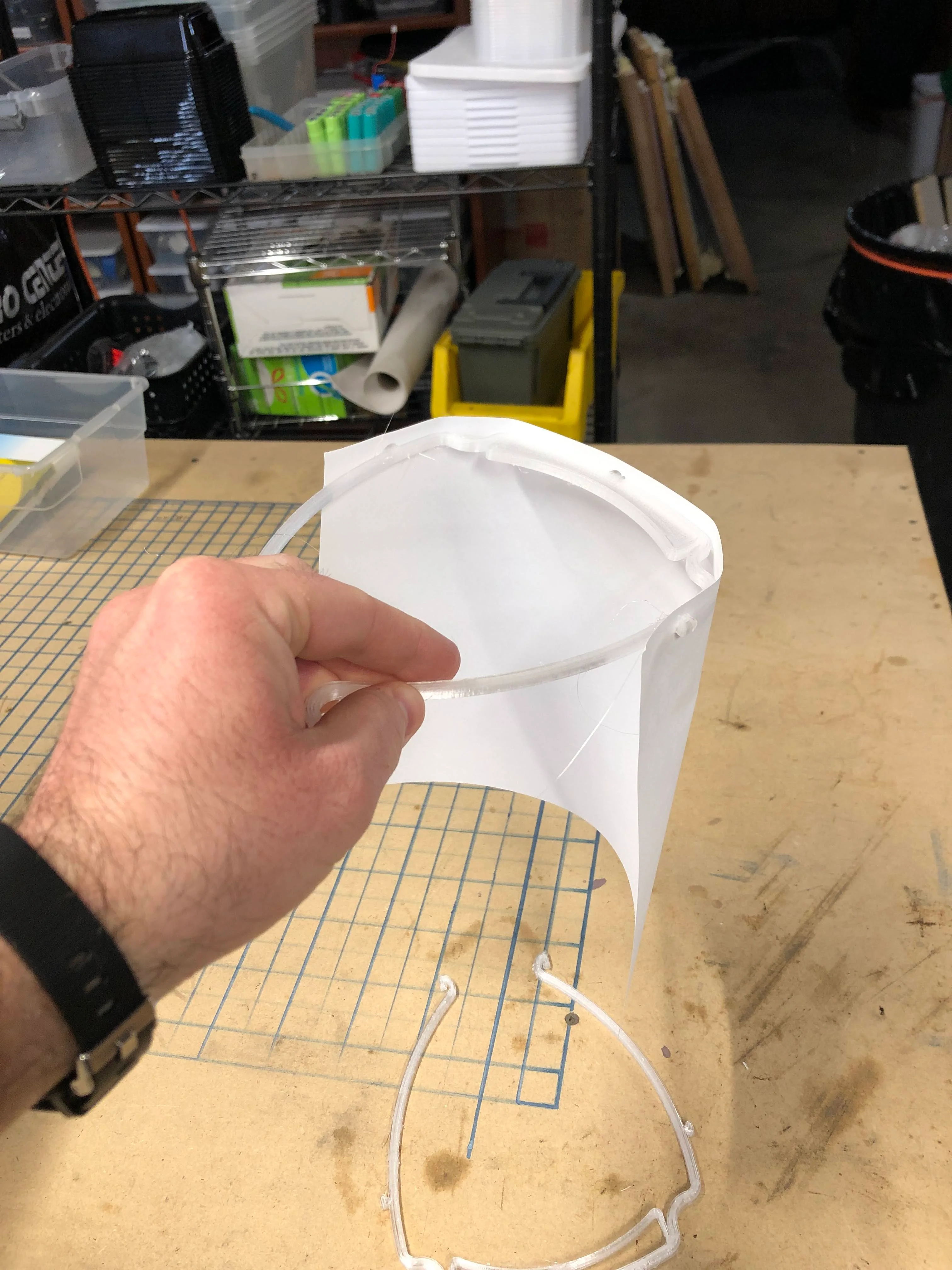 A clear face shield prototype being assembled by hand