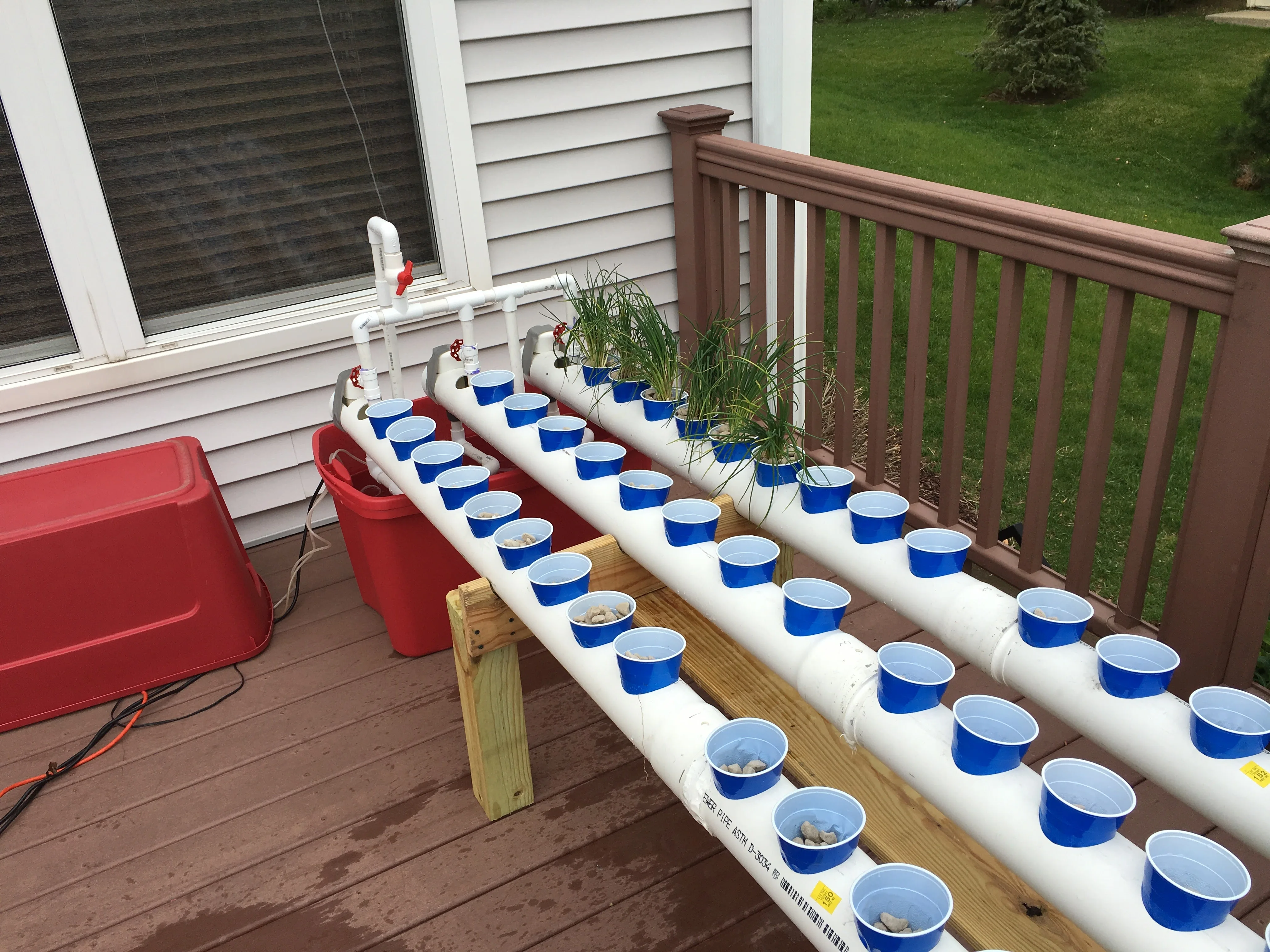 Empty multi-level PVC hydroponic frame on a deck